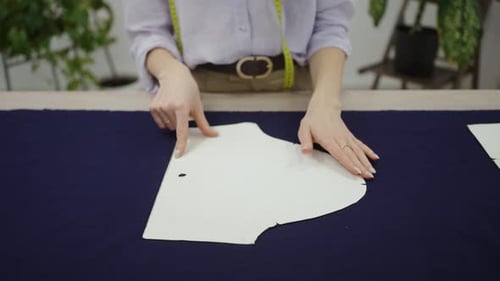 Woman Traces Pattern onto Blue Fabric for Sewing