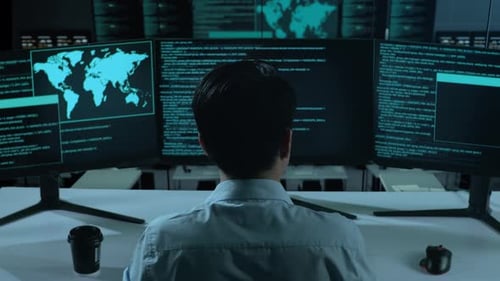 Asian Man Using Computer To Write Code With Multiple Screens In office