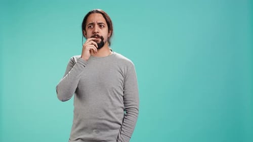 Man Thinking and Touching Face on Blue Background