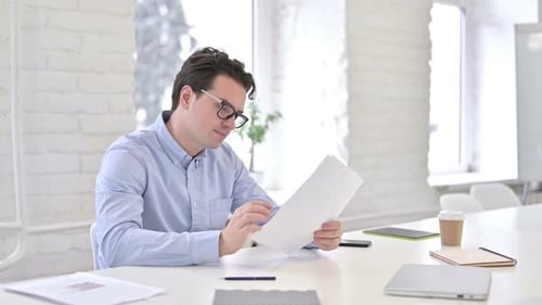 Hardworking Working Young Man Thinking and Writing on Paper