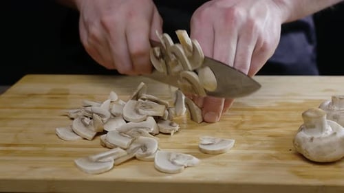 Chef Slicing Mushrooms on Cutting Board Close Up