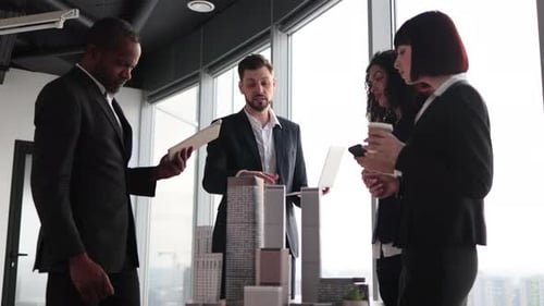 Handsome Bearded Male Team Leader Having a Presentation on Table with 3d City Model