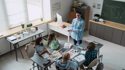 Teacher Using Wind Turbine Model to Teach Four Students in classroom