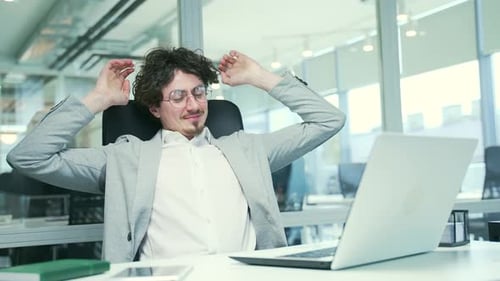 Man Relaxing After Working on Laptop in Office