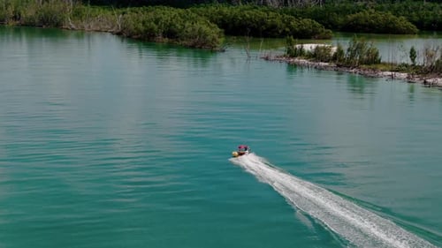 Boat Speeds Through Crystal Clear Waterway