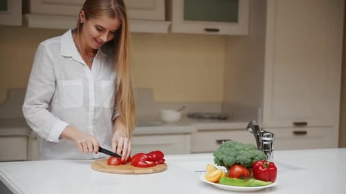 Woman Cutting Vegetables in a Bright Modern Kitchen