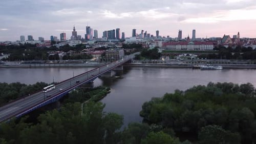 Cinematic drone footage of Warsaw skyline with vistula river and bridge filled with traffic