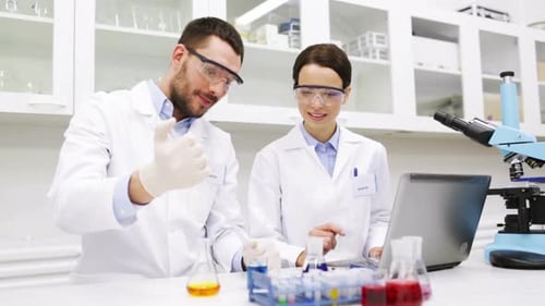 Science, Chemistry, Technology, Biology and People Concept - Young Scientists with Pipette