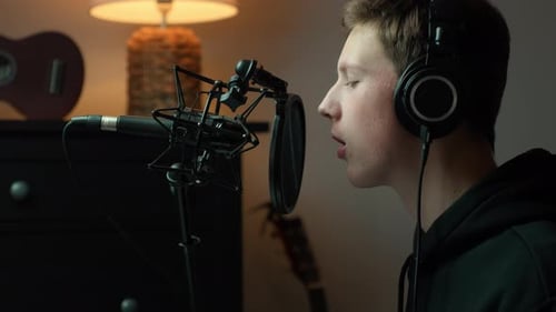 Young Music Producer Recording Vocals in Cozy Home Studio Setup