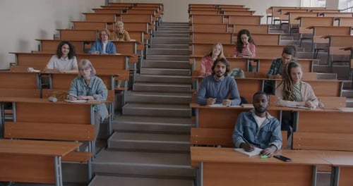 Multiracial Group of Students Listening to Lecture and Talking Studying in University While