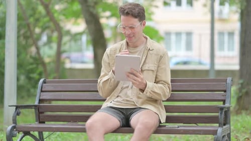Young Adult on Tablet Video Call in Park