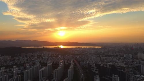 Aerial View of Sunset Over Cityscape and Lake in Vibrant Skyline