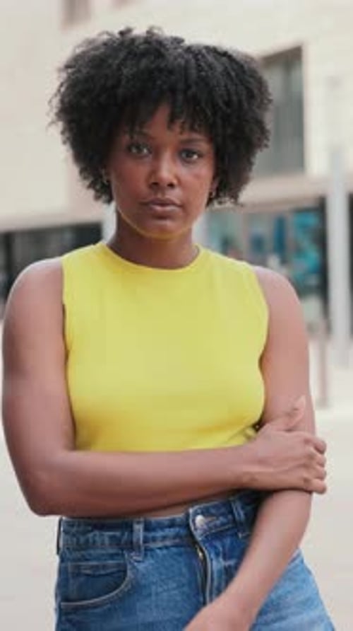 Portrait individuel vertical d'une adolescente afro-américaine sérieuse regardant la caméra à l'extérieur