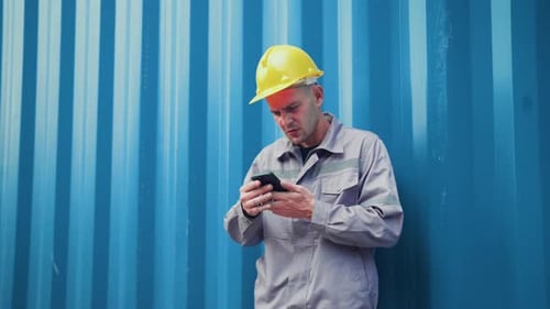 Worker in a hard hat looking at his smartphone