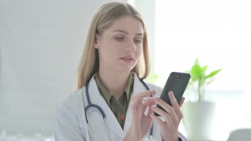 Woman Doctor Using Smartphone in Clinic Setting
