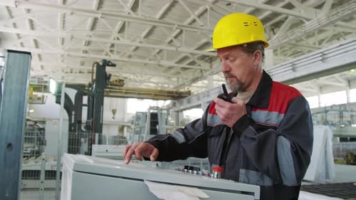 Male Engineer Using Walkie Talkie and Industrial Machine at Plant