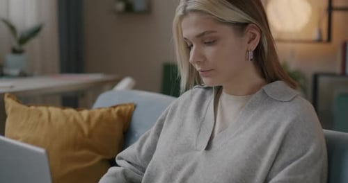 Young Woman Using Laptop Computer on Couch