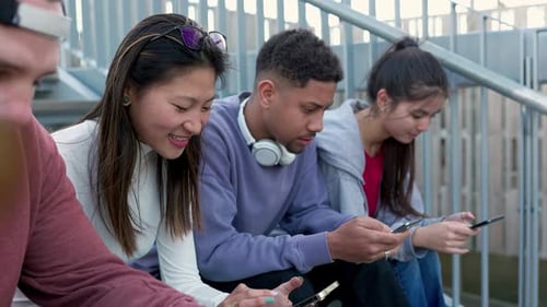 Friends Smiling and Using Phones on Urban Steps
