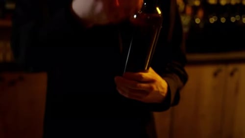 Verser du vin dans un doseur Le barman verse un filet de vin rouge dans un doseur au-dessus d'un bar