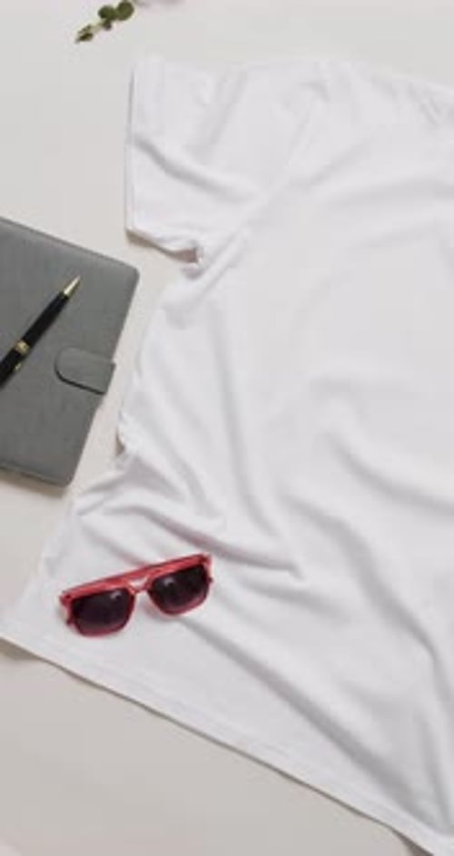 Video of orange t shirt, denim trousers, sunglasses and copy space on white background