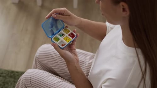 Young Woman Taking Daily Supplement in Morning