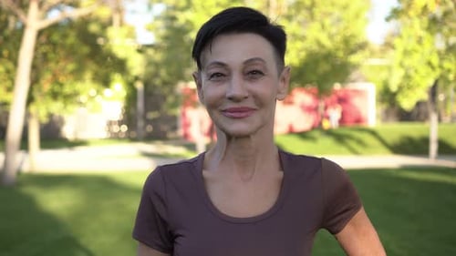 Smiling Woman With Short Hair in Urban Park