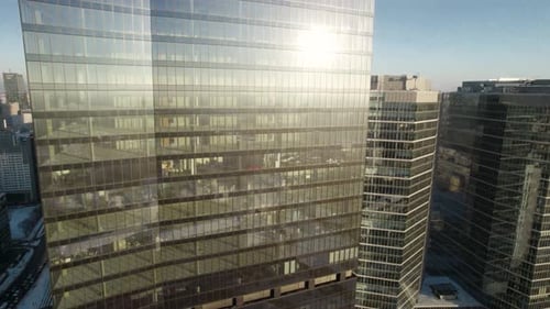 Aerial orbit over the glass facade of the office building with empty floors due to the financial cri