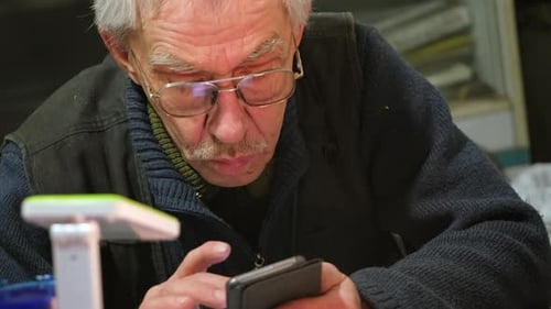 Senior Man Using Smartphone Indoors, Close-Up