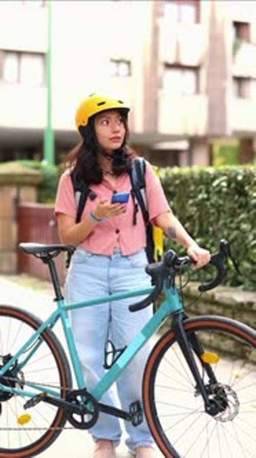 Woman with Bike and Food Delivery Bag Looks Around