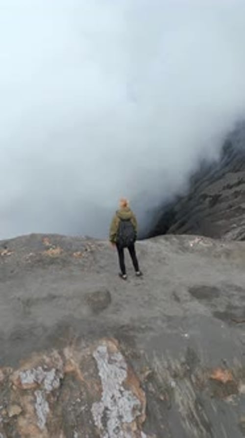 Woman Standing at the Rim of Steaming Mount Bromo Volcano Crater in Indonesia