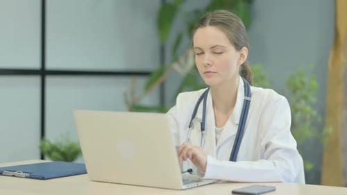 Young Doctor Working On Laptop and Smiling