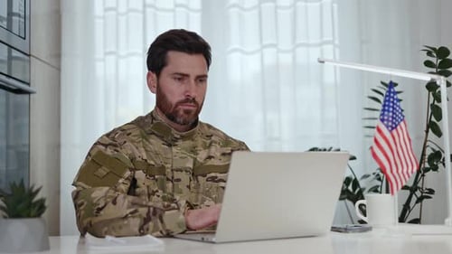 Worker of American Military Creating Articles Related to Army Topics on Laptop