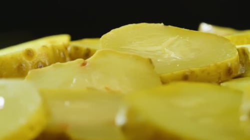 Close up of sliced pickles on black background