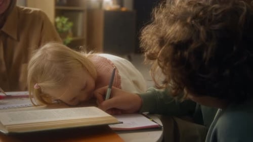 Brother Helping Little Sister with Homework at Home