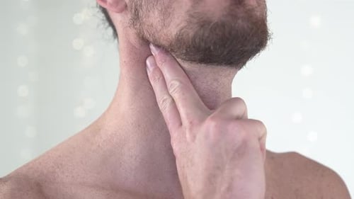 Foto em close-up de um homem de topless sentindo o pulso carotídeo com os dedos