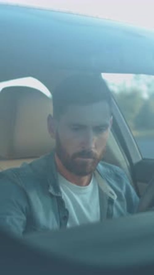 Motorista concentra operador masculino extremamente sério em jeans, observa o painel e a navegação