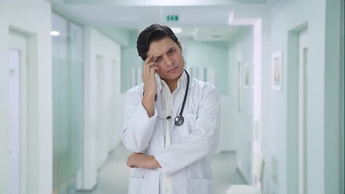 Confused Indian male doctor thinking