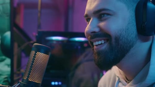 Smiling Man Wearing Headphones With Microphone and Computer