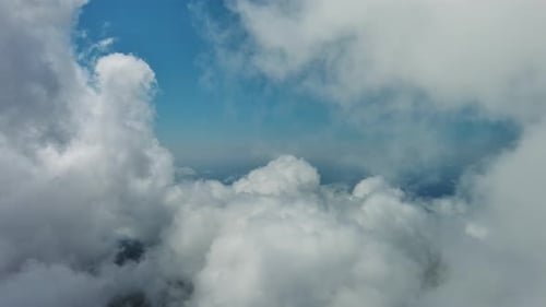 Flying Through White Clouds Over Sea