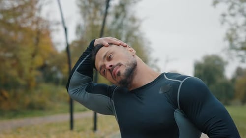 Active Fit Man Engaged in Physical Exercise Stretching Neck Outdoor Street Male Athlete in