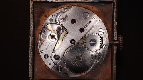 Old clock mechanism close-up on a black background. Vintage mechanical watch.