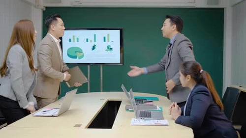 Business Colleagues Review Presentation in Conference Room