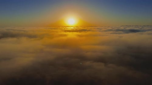 Salida del sol de un paisaje nublado sobre siluetas de montañas