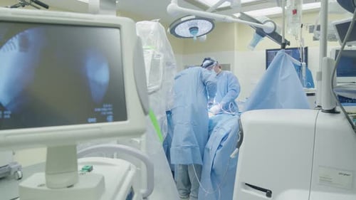 Medical team performs surgery in operating room.