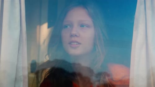 Teenager woman opening curtains near window and looking around with happy at home in the morning.