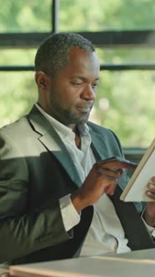 Man in Suit Using Tablet at Desk