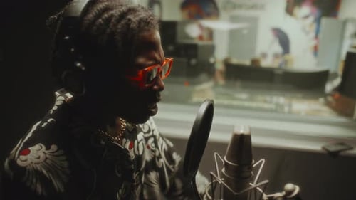 Vibey Black Musician Recording Song in Professional Studio Booth