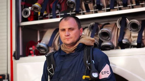 Firefighter Standing Near Firetruck Full of Hoses