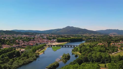 Small town near a lake with mountains - Drone establishing shot