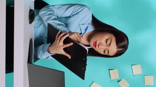 Office Secretary Filling Out Checklist